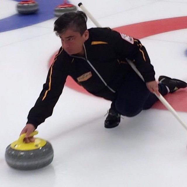 Mary delivering a yellow-handled curling stone