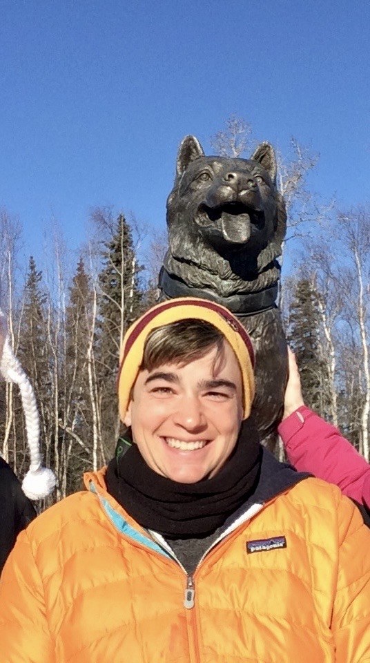 Mary outdoors in a bright orange winter jacket
